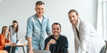 Team of colleagues smiling and working together in open office